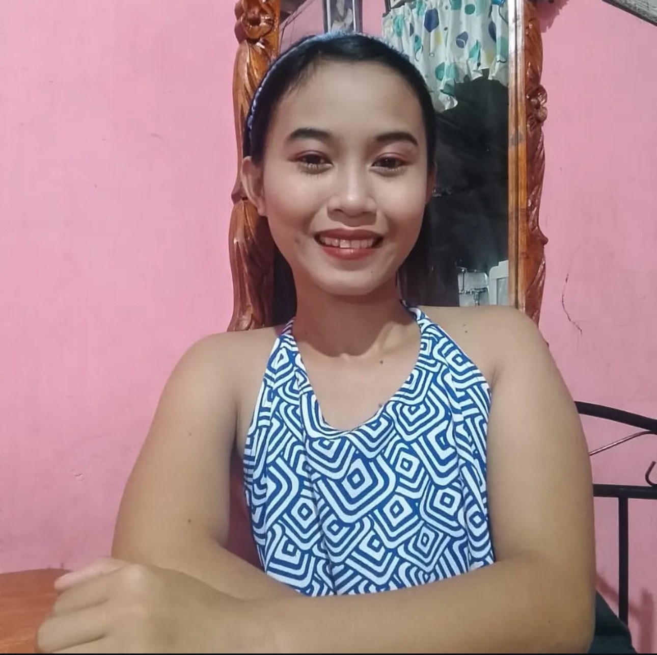 Mae Mae smiling in a pink room